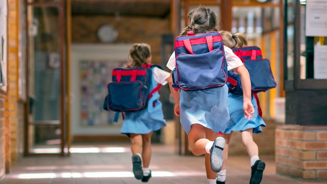 schoolchildren running to start class at school